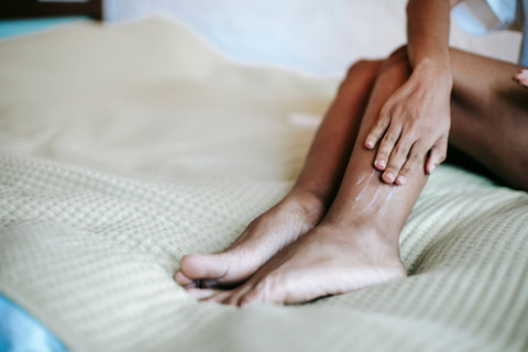 Woman applying moisturizer to her legs after bathing. Photo: Sora Shimazaki / Pexels.