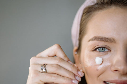 Woman gently applying facial cream during a skincare routine