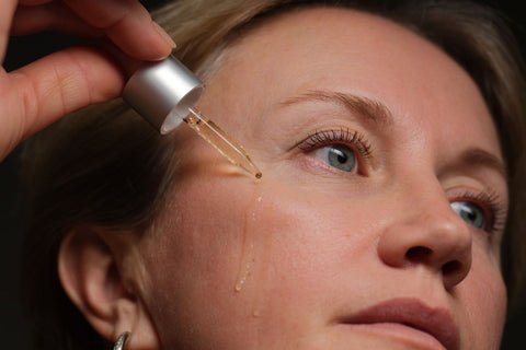 Woman applying facial serum with a dropper; illustrative skincare photograph