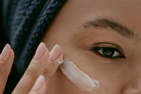 Woman gently applying face moisturizer to her cheek. Photo: cottonbro studio via Pexels.
