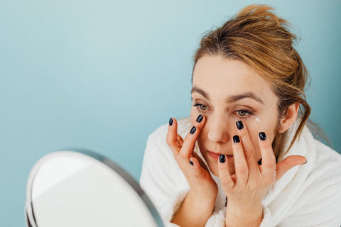 Woman applying eye cream under the eyes during her skincare routine