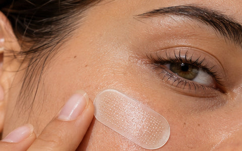 Close-up of a transparent microneedle patch applied to a cheek