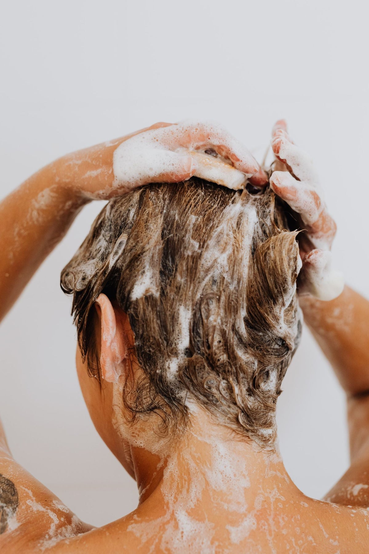 Woman gently shampooing her scalp in the shower, Pexels