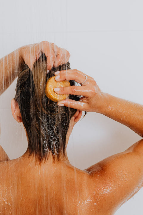 Woman washing her hair under running shower water. Photo: kaboompics via Pexels.
