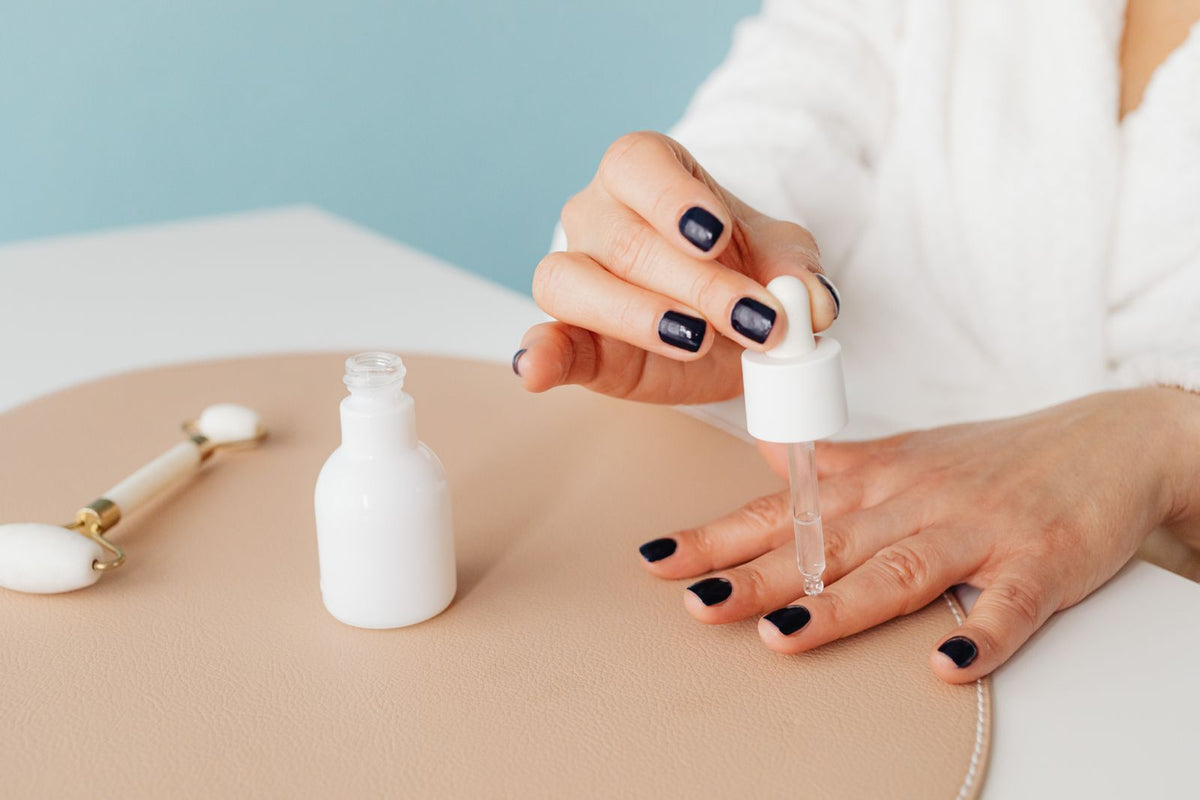 Close-up of a dropper applying oil to a fingernail and cuticle, Kaboompics via Pexels
