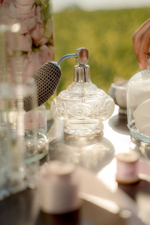 Vintage perfume bottle among flowers. Photo: Ron Lach via Pexels.