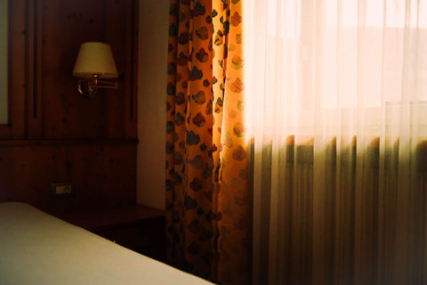 Sunlight filtering through bedroom curtains. Photo: Tobi via Pexels.